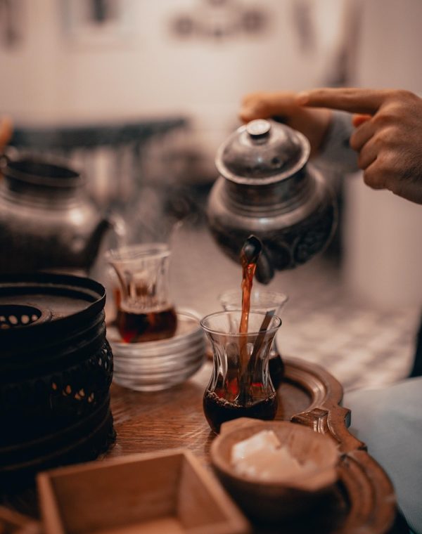 夜间球房一角，两三位球友围在台边用手机回看刚才那杆的慢动作击球视频